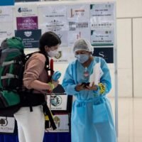 Eine Passagierin lässt ihre Daten bei der Ankunft am Flughafen Suvarnabhumi am Dienstag von einem Hotelvertreter überprüfen, während Thailand die quarantänefreie Reise wieder aufnimmt.