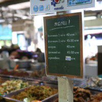 Eine Speisekarte wird am 12. Januar 2022 vor einem Lebensmittelgeschäft im Stadtteil Bueng Kum in Bangkok aufgestellt.
