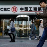 Menschen gehen an einer Filiale der Industrial and Commercial Bank of China (ICBC) in Peking vorbei. Der chinesische Kreditgeber hat die Ausstellung von auf Dollar lautenden Akkreditiven für den Kauf russischer Rohstoffe eingestellt