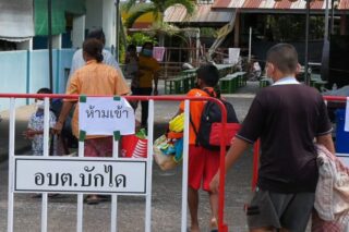 Mit Coronavirus infizierte Schüler betreten am Montag ein kommunales Isolationszentrum der Ban Run School im Bezirk Phanom Dong Rak in der Provinz Surin.