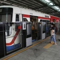 Pendler warten am Dienstag am Bahnhof Khu Khot auf der Grünen Linie in der Provinz Pathum Thani darauf, in einen Zug einzusteigen