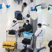 Reisende schützen sich am Mittwoch am Flughafen Suvarnahumi in Samut Prakan gut vor einer Infektion, als das Land 23.557 neue Covid-19 Fälle und 38 weitere Todesfälle verzeichnete