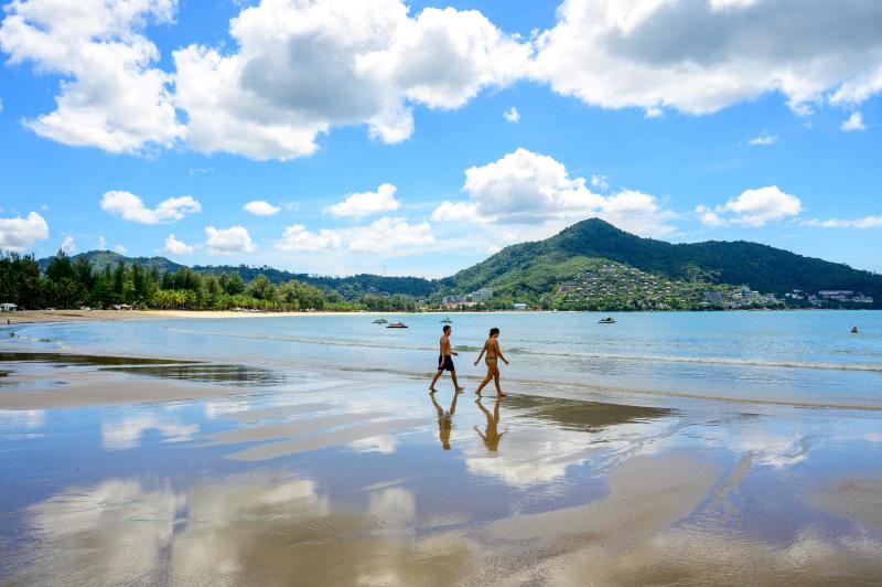Touristen gehen am 2. November 2021 an einem Strand auf der thailändischen Insel Phuket spazieren.