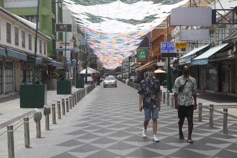 Zwei Männer gehen am 13. April 2021 eine verlassene Khao San Road in Bangkok entlang. Die Pandemie wird voraussichtlich die Tourismusstimmung dämpfen