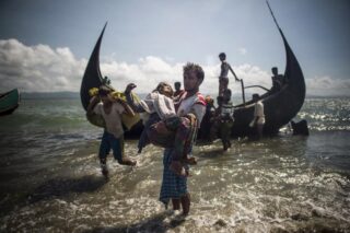 Auf diesem Foto, das am 30. September 2017 aufgenommen wurde, hilft ein Mann aus Bangladesch muslimischen Rohingya-Flüchtlingen beim Aussteigen aus einem Boot