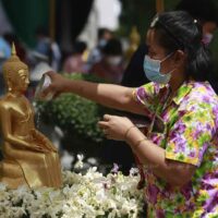 Die Menschen baden traditionell Buddha Statuen während der Songkran Feiertage