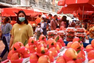 Die Menschen stöbern am 24. Februar 2022 in der Yaowarat Road in Bangkok nach frischem Obst.
