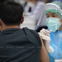 Ein Angehöriger der Gesundheitsberufe impft am Mittwoch einen Mann an der Bang Sue Grand Station gegen Covid-19