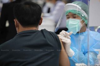 Ein Angehöriger der Gesundheitsberufe impft am Mittwoch einen Mann an der Bang Sue Grand Station gegen Covid-19
