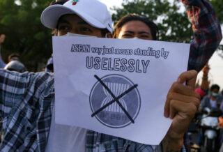 Ein Demonstrant gegen die Junta von Myanmar hält am 5. Juni 2021 in Mandalay, Myanmar, ein Plakat hoch, auf dem er die ASEAN kritisiert.
