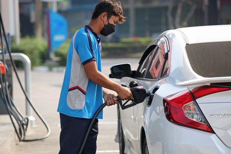 Ein Mitarbeiter einer PTT Tankstelle betankt ein Auto, während die Kraftstoffpreise in die Höhe schießen.