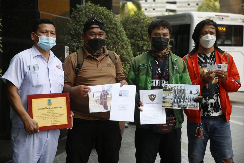 Eine Gruppe thailändischer Männer beweist ihre militärische Erfahrung in der Witthayu Road in Bangkok, wo sich die ukrainische Botschaft befindet.