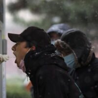 Einem Mann wird am Freitag in einem mobilen Nukleinsäure-Testzentrum in Peking, China, eine Abstrichprobe entnommen.