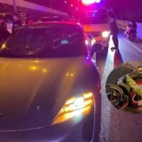 Ermittler untersuchen die Unfallstelle, bei der ein Porsche-Sportwagen am frühen Samstag nahe der Taksin Brücke in Bangkok mit einem Motorrad zusammenstieß.