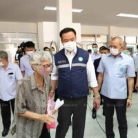 Gesundheitsministerin Anutin Charnvirakul trifft am Dienstag ältere Menschen in einer vorübergehenden Covid-19 Impfstation in einer Gemeinde in der Provinz Nonthaburi.