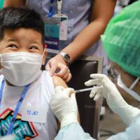 Gesundheitspersonal impft Kinder am Donnerstag auf der Thailand International Health Expo 2022 im Einkaufszentrum Siam Paragon in Bangkok gegen Covid-19