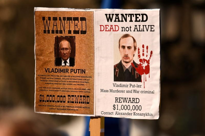 Menschen halten ein „Wanted“-Plakat, das den russischen Präsidenten Wladimir Putin während einer Anti-Kriegs-Demonstration „Stop the War. Peace and Solidarity for the People in Ukraine“ zeigt