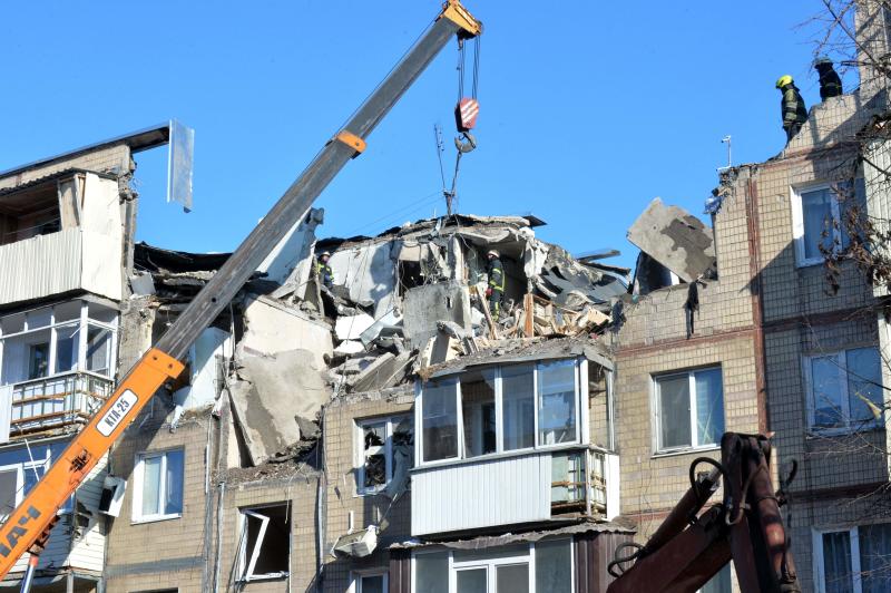 Retter entfernen am 16. März 2022 inmitten der andauernden russischen Invasion in der Ukraine Trümmer aus einem Wohngebäude, das durch Beschuss in Charkiw beschädigt wurde.