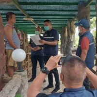 Die Polizei der Abteilung zur Unterdrückung von Wirtschaftskriminalität besucht am Sonntag Samrit Buapa, der links steht, mit einem Haftbefehl in seinem Haus im Bezirk Nam Yuen von Ubon Ratchathani.