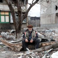 Ein Anwohner sitzt am Montag in der Nähe eines beschädigten Wohnhauses in der südlichen Hafenstadt Mariupol in der Ukraine.
