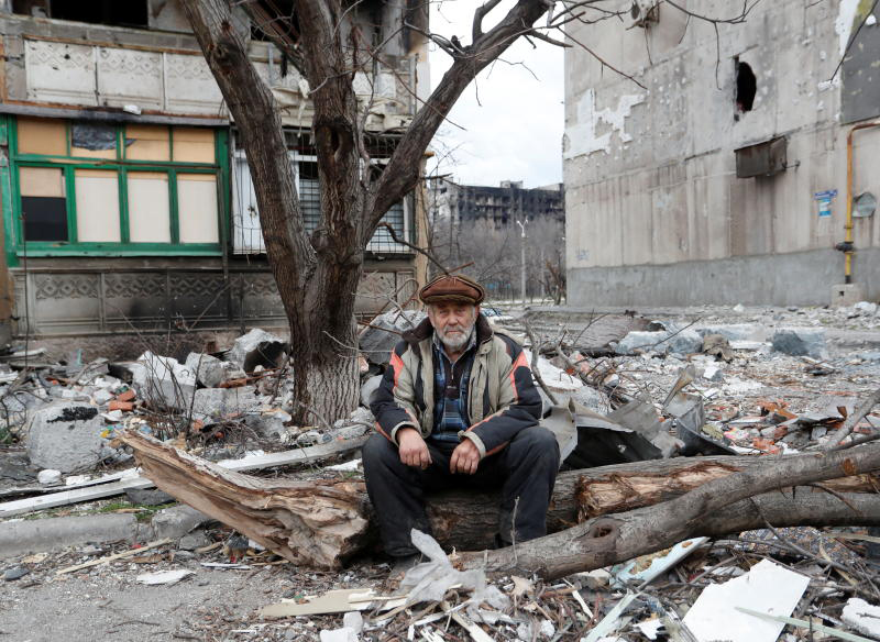 Ein Anwohner sitzt am Montag in der Nähe eines beschädigten Wohnhauses in der südlichen Hafenstadt Mariupol in der Ukraine.