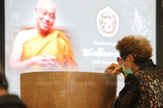 Ein Gläubiger nimmt am 17. März 2022 im Wat Bowonniwet Vihara an einem königlich gesponserten Baderitual vor einem Bild des verstorbenen Somdet Phra Wannarat teil