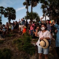 Einheimische und Touristen, die Gesichtsmasken tragen, beobachten am Samstag einen Sonnenuntergang vom Kap Phromthep auf der Insel Phuket