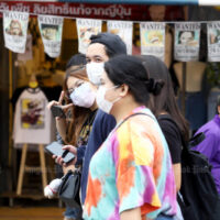 Menschen, die Gesichtsmasken tragen, gehen am 2. April 2022 auf dem Chatuchak Wochenendmarkt in Bangkok spazieren