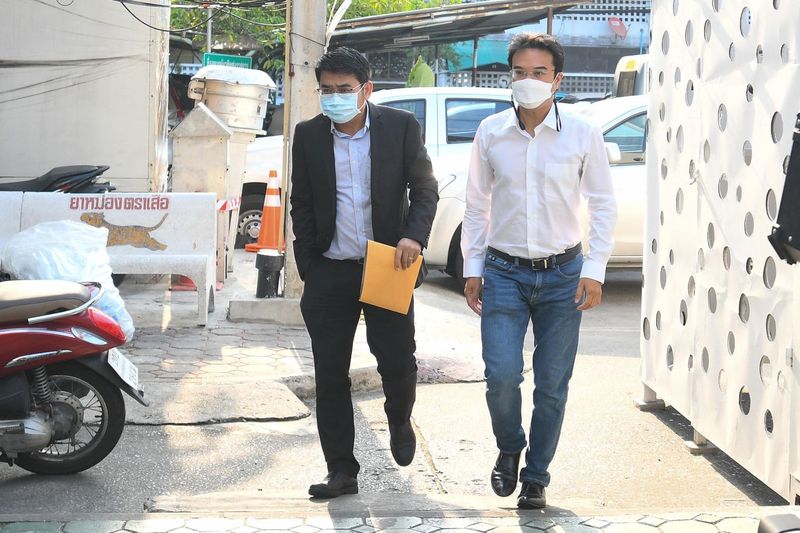 Prinn Panitchpakdi (rechts), ein ehemaliger stellvertretender Vorsitzender der Demokratischen Partei, kommt am Samstagmorgen auf der Lumphini-Polizeistation in Bangkok an