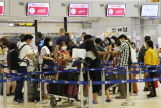 Reisende stehen während der Songkran Feiertage Schlange, um bei den Transportunternehmen am Don Mueang International Airport einzuchecken.