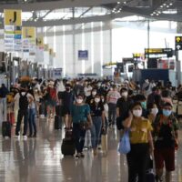 Reisende tragen am 9. April am Flughafen Suvarnabhumi Gesichtsmasken, um eine Covid-19 Infektion zu verhindern.