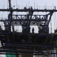 Arbeiter werden beim Zusammenbau einer Überführung an der Kreuzung Na Ranong gesehen. Bauarbeiter werden nach Tageslöhnen bezahlt – ein Betrag, der seit zwei Jahren nicht mehr gestiegen ist