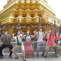 Besucher ahmen am Sonntag die Statuen am Fuß eines goldenen Chedi im Tempel des Smaragd Buddha im Grand Palace in Bangkok nach
