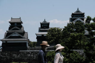 Besucher, die Gesichtsschutzmasken tragen, gehen am Mittwoch an der Burg Kumamoto in Kumamoto, Japan, vorbei.