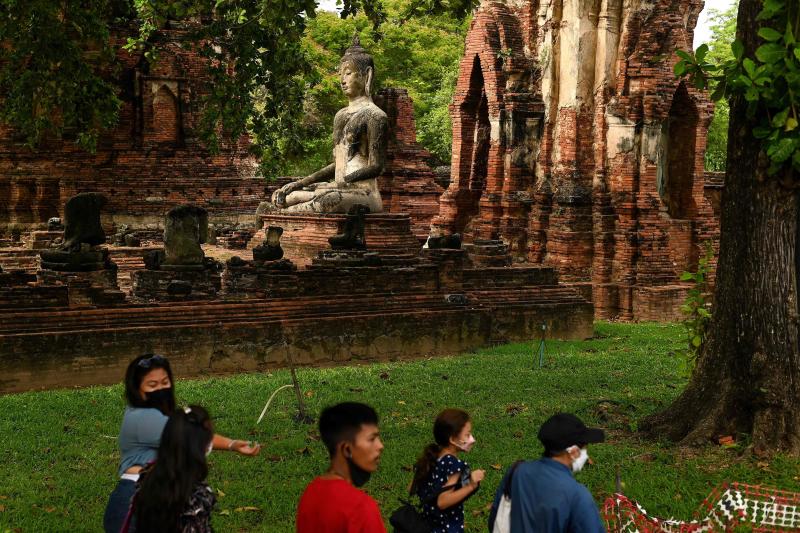 Besucher, die zum Schutz vor dem Ausbruch des Coronavirus Gesichtsmasken tragen, besuchen am Freitag den Wat Mahathat-Komplex aus dem 14. Jahrhundert in der alten Hauptstadt Ayutthaya