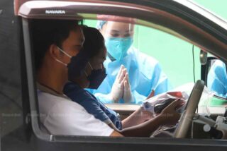 Covid-19-infizierte Personen mit leichten Symptomen fahren ein und erhalten Covid-19 Medikamente bei einem Drive-Thru Service an einer öffentlichen Van-Station im Bezirk Thanyaburi von Pathum Thani