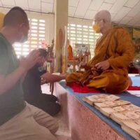 Der ehemalige amtierende Abt Pongsakorn Chankaeo, 23, links, früher bekannt als Phra Kato, wird am Mittwochabend gesehen, wie er das von ihm geliehene Geld zurückgibt