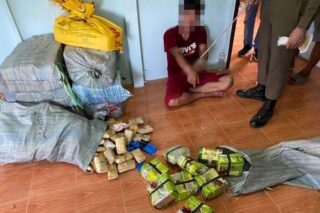 Ein Verdächtiger zeigt bei einer Razzia in seinem Haus im Bezirk Lom Sak in Phetchabun auf Pakete mit Speedpillen und Crystal Methamphetamin.