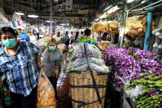 Ein Verkäufer bewegt am 12. April 2022 Körbe mit Orchideen auf dem Blumengroßmarkt Pak Khlong Talat in Bangkok
