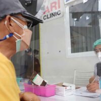 Ein medizinischer Mitarbeiter konsultiert einen Patienten im Taksin-Krankenhaus, einer von neun vom Rathaus betriebenen Einrichtungen, die Menschen mit langem Covid behandeln