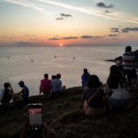 Einheimische und Touristen beobachten am 9. April 2022 einen Sonnenuntergang vom Kap Phromthep auf der Insel Phuket.