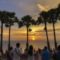 Einheimische und ausländische Touristen genießen den Sonnenuntergang am Kap Promthep in Phuket