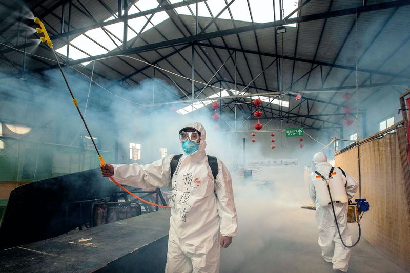 Freiwillige sprühen Desinfektionsmittel auf einem Markt als vorbeugende Maßnahme gegen das Coronavirus in der Grenzstadt Suifenhe in der nordöstlichen Provinz Heilongjiang in China im Jahr 2020.