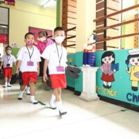 Inmitten von Maßnahmen zur Krankheitsbekämpfung und der sich verbessernden lokalen Covid-19-Situation sind die Schüler am Dienstag wieder an der Wat Rajabopit School in Bangkok.