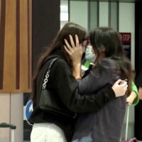 Menschen umarmen sich im Ankunftsbereich des Flughafens Auckland, als Australier ankamen