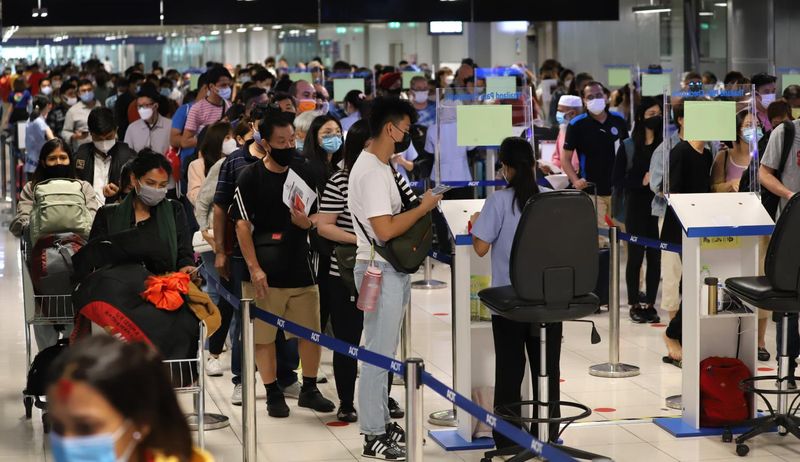 Passagiere warten, bis sie an der Reihe sind, um am Sonntag einen QR-Code von Thailand Pass bei den Gesundheitsbehörden am Suvarnabhumi International Airport einzureichen