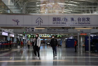 Reisende gehen am 23. März 2022 in einer Terminalhalle des Beijing Capital International Airport in Peking spazieren.