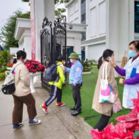 Schüler betreten eine Schule, da die Normen für die Coronavirus Krankheit für Schulen gelockert und am 8. Februar 2022 in Hanoi wiedereröffnet wurden