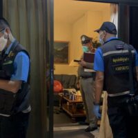 Zwei forensische Polizisten sammeln Beweise im Haus eines Norwegers, der am Samstag im Distrikt Bang Lamung in der Provinz Chon Buri tot aufgefunden wurde.