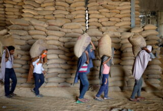 Arbeiter tragen Weizensäcke zum Sieben in eine Getreidemühle am Stadtrand von Ahmedabad am 16. Mai 2022. Indien ist eines der Länder, die den Export einschränken